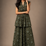 Model wearing an Olive Green printed sleeveless co-ord set with handcrafted tassel neckline and flowing layered maxi skirt in a luxury studio setting.