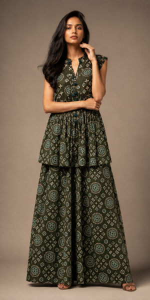 Model wearing an Olive Green printed sleeveless co-ord set with handcrafted tassel neckline and flowing layered maxi skirt in a luxury studio setting.
