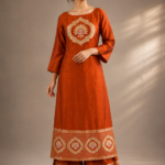 Rust Orange Pure Banarasi Silk Kurta and Pant Set featuring woven peacock motif, boat neckline, 3/4 sleeves and Banarasi woven border.