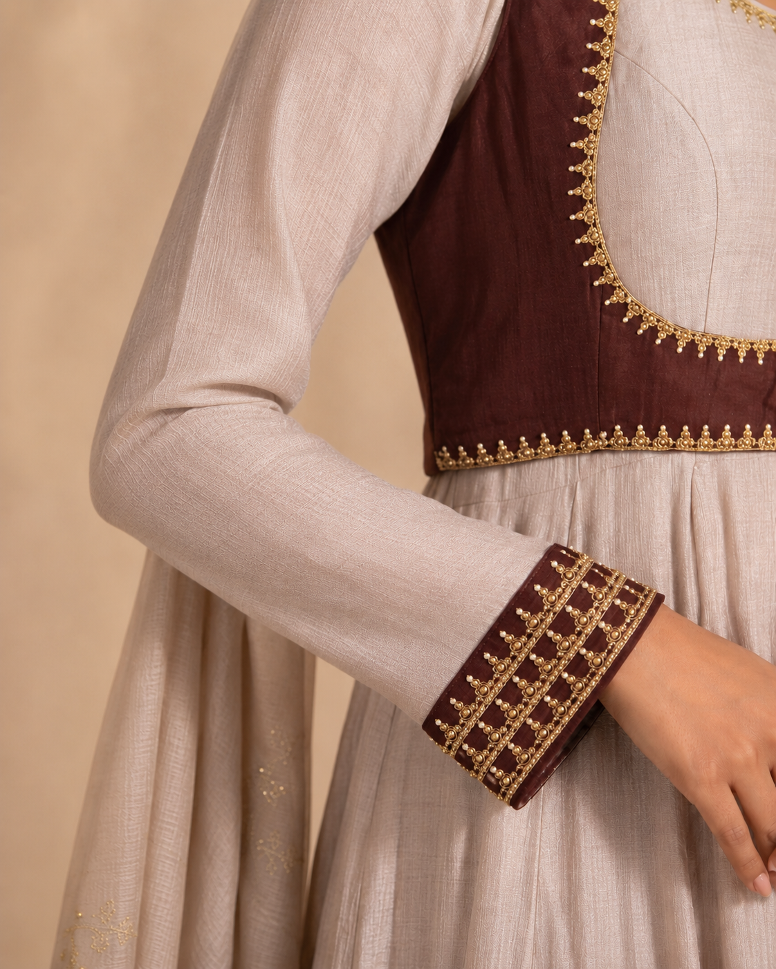 brown sleeve close up Noor-e-Chand Ensemble - A luxury ivory chanderi Anarkali with hand-embroidered brown sleeveless jacket and self-coloured dupatta featuring diagonal Chand Baali embroidery.